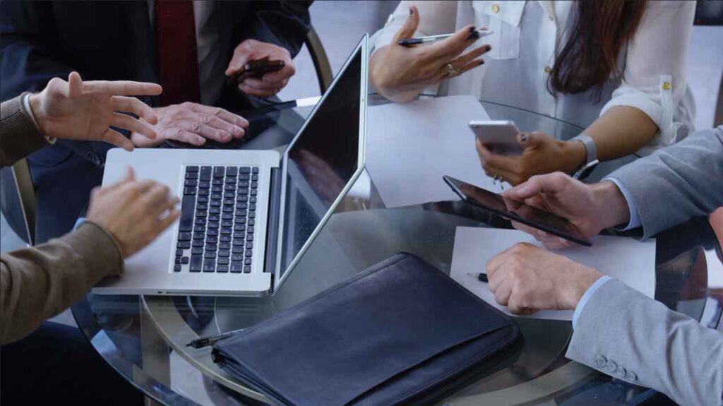 hands around a table meeting